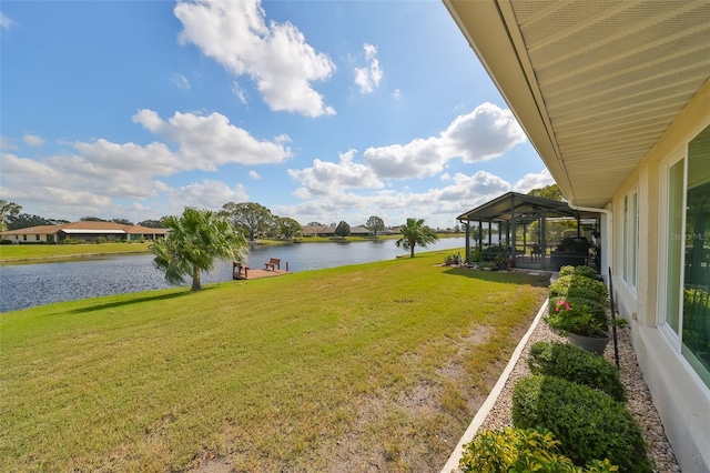 view of yard with a sunroom and a water view