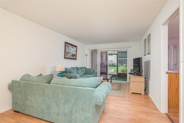 living room with a textured ceiling and light hardwood / wood-style floors