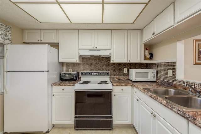 kitchen with white appliances, light tile patterned floors, sink, and white cabinets