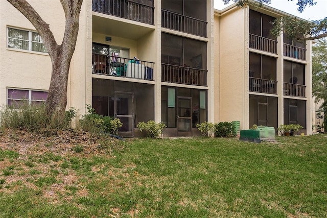 back of house with a balcony and a lawn