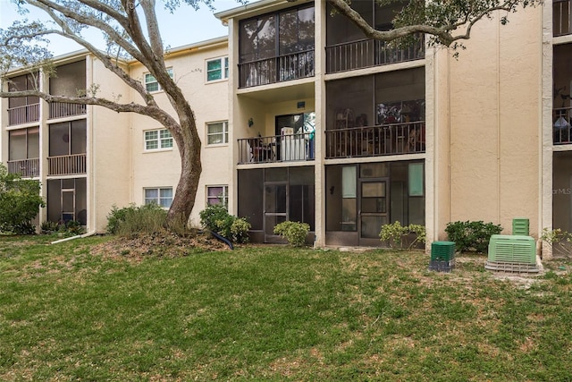 back of house featuring a lawn and a balcony