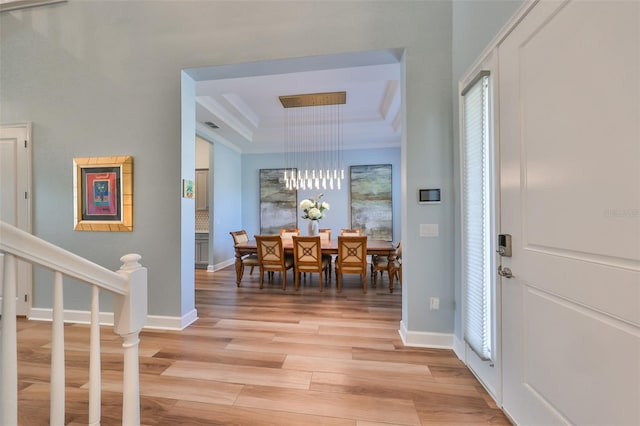 entrance foyer with a raised ceiling and light hardwood / wood-style flooring