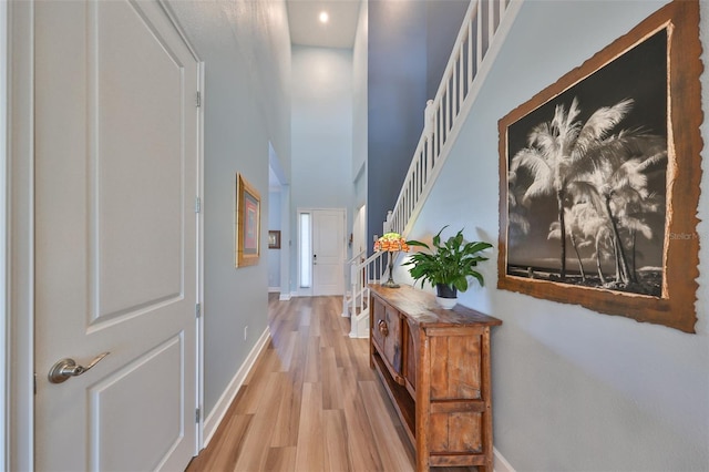 hallway featuring light hardwood / wood-style floors and a high ceiling