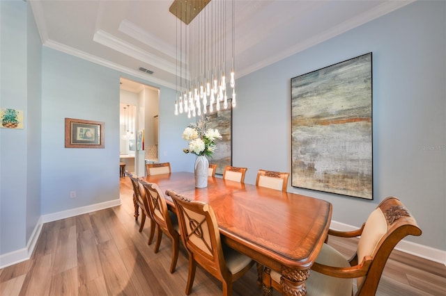 dining space featuring ornamental molding and hardwood / wood-style flooring