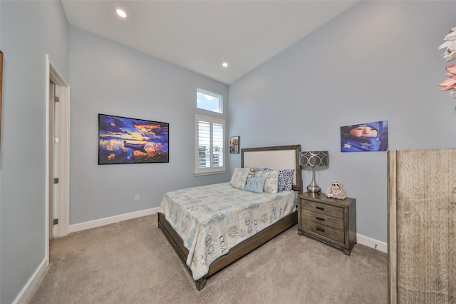 bedroom featuring light carpet and high vaulted ceiling