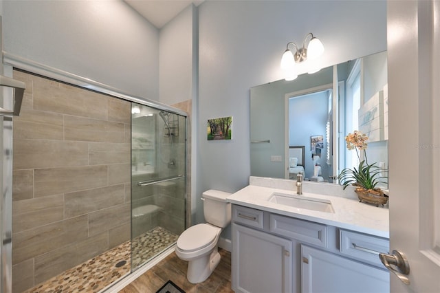 bathroom with vanity, hardwood / wood-style floors, toilet, and walk in shower