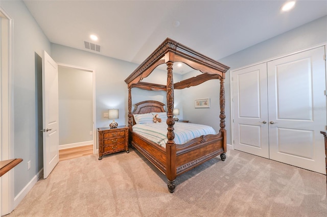 bedroom with light carpet and a closet