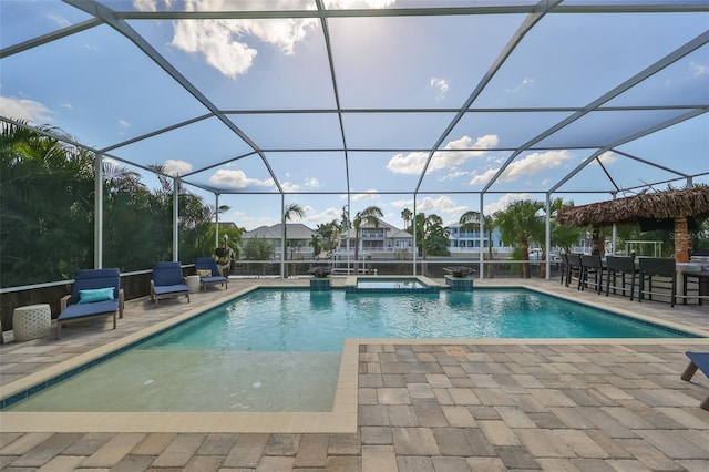 view of swimming pool featuring a patio area and glass enclosure