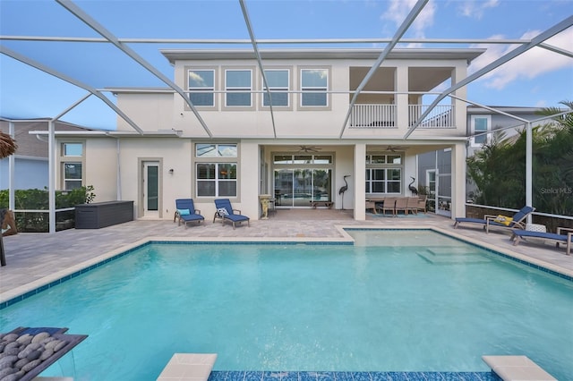 back of property with a patio, ceiling fan, and glass enclosure