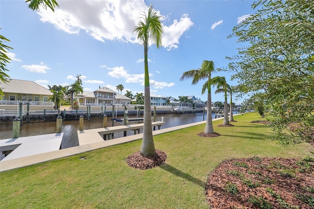 dock area with a lawn and a water view