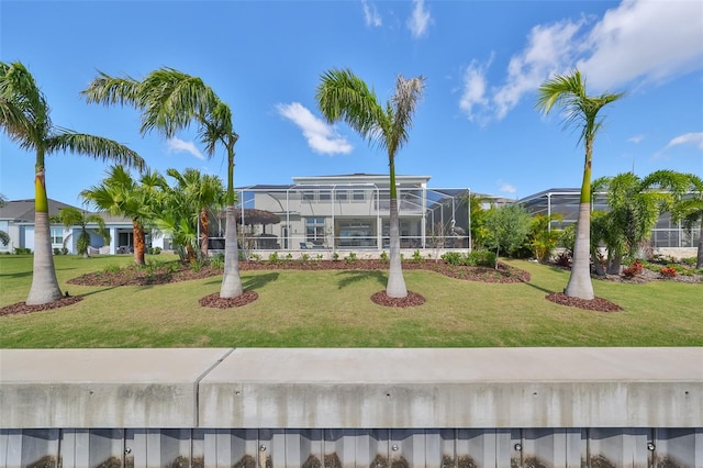 view of front of house with a lanai and a front lawn