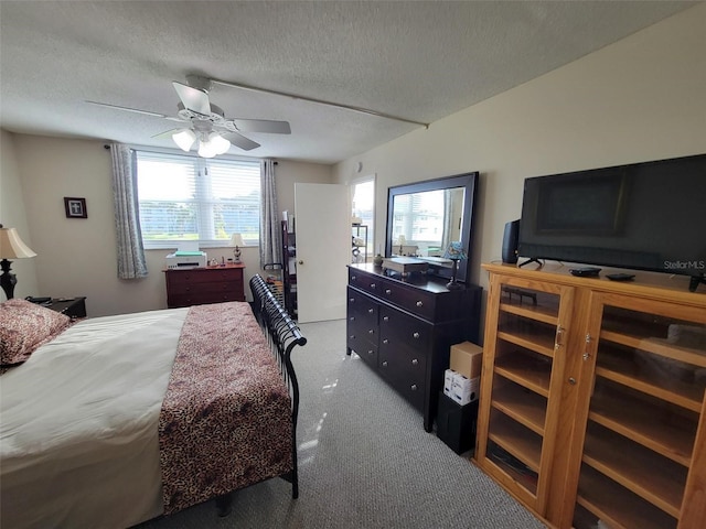 bedroom featuring multiple windows, a textured ceiling, and ceiling fan