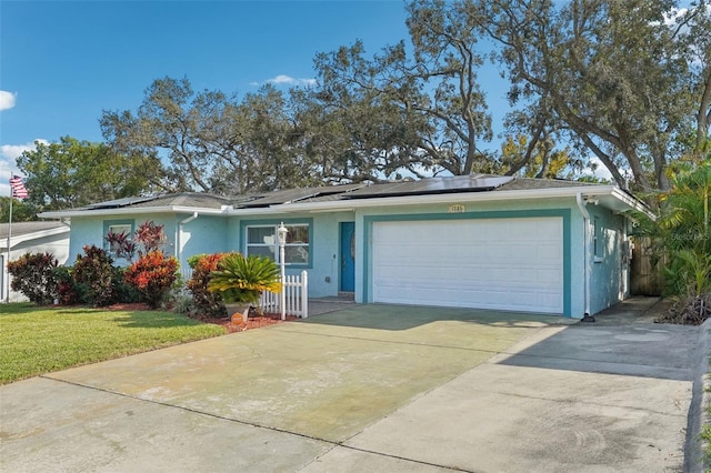 single story home with a front lawn, a garage, and solar panels