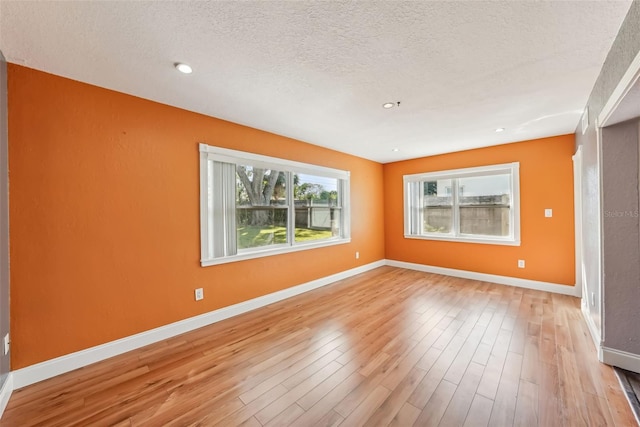 spare room featuring hardwood / wood-style floors and a textured ceiling