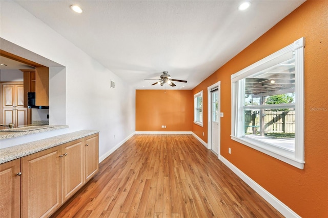 unfurnished living room featuring light hardwood / wood-style flooring and ceiling fan