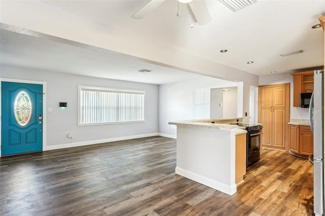 kitchen with black appliances, dark hardwood / wood-style floors, ceiling fan, and a center island with sink