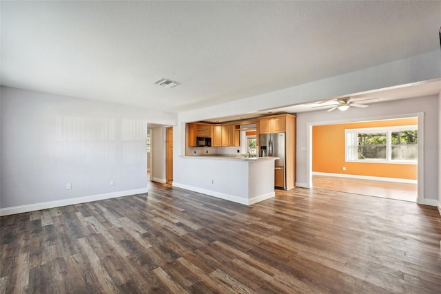 unfurnished living room with ceiling fan and dark wood-type flooring