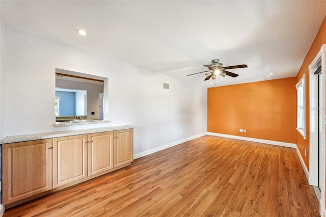 interior space featuring light wood-type flooring, ceiling fan, and sink