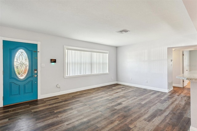 entrance foyer with a textured ceiling and dark hardwood / wood-style floors