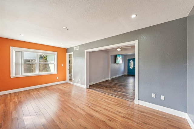 spare room featuring ceiling fan, wood-type flooring, and a textured ceiling