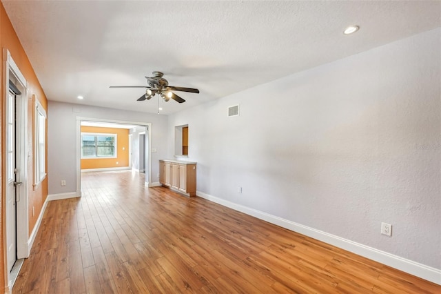 unfurnished living room with light hardwood / wood-style flooring and ceiling fan