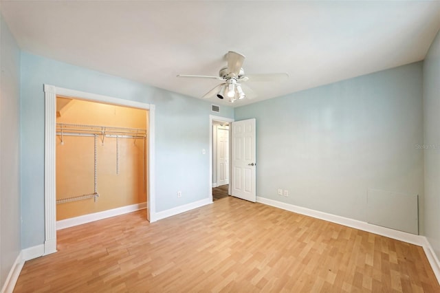 unfurnished bedroom with ceiling fan, light wood-type flooring, and a closet