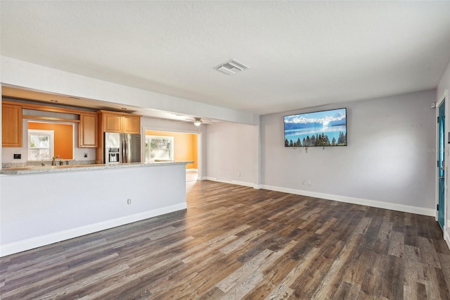 unfurnished living room with ceiling fan, dark hardwood / wood-style flooring, and sink