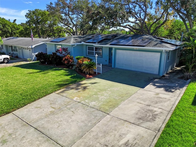 single story home with solar panels, a garage, and a front yard