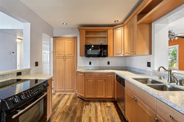 kitchen with light stone countertops, ceiling fan, black appliances, sink, and dark hardwood / wood-style floors