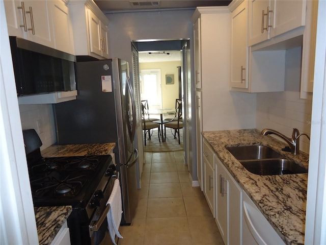 kitchen featuring white cabinets, black gas range, backsplash, and sink