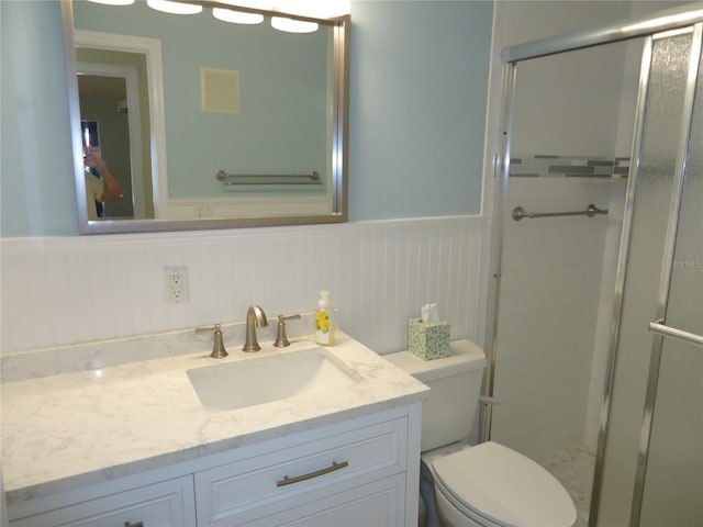 bathroom featuring walk in shower, vanity, and toilet