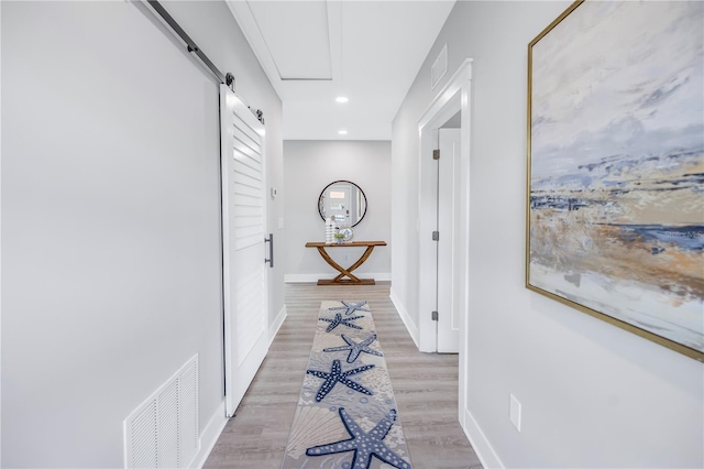 hall featuring light hardwood / wood-style flooring and a barn door