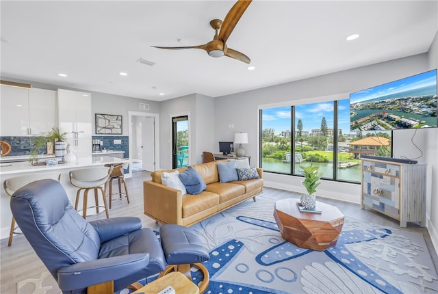 living room featuring ceiling fan and light hardwood / wood-style flooring