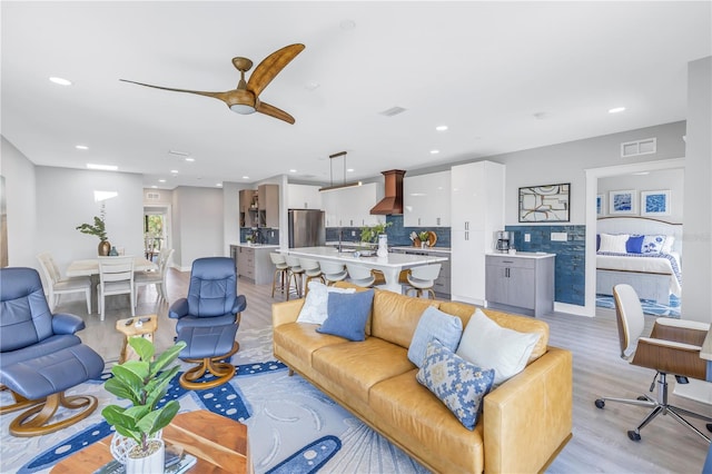 living room with light hardwood / wood-style flooring and ceiling fan