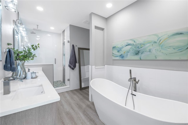 bathroom featuring vanity, shower with separate bathtub, and hardwood / wood-style floors