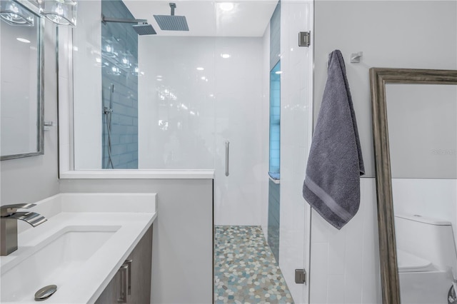 bathroom featuring vanity, a shower with shower door, and toilet