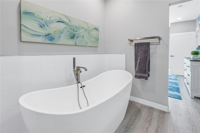 bathroom with a bath, hardwood / wood-style floors, and vanity