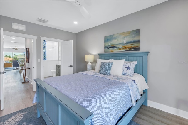 bedroom featuring dark hardwood / wood-style flooring, ensuite bathroom, and ceiling fan