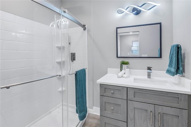 bathroom with a shower with door, vanity, and wood-type flooring