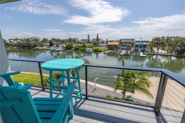 view of dock with a balcony and a water view