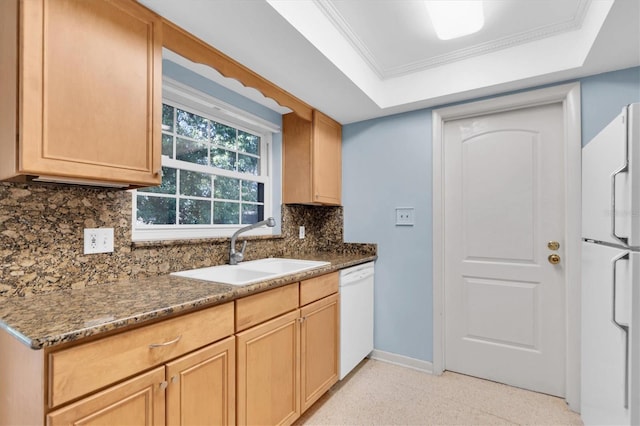 kitchen featuring decorative backsplash, a raised ceiling, dark stone countertops, sink, and white appliances