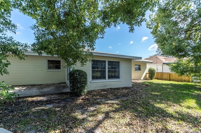 rear view of property with a patio and a lawn