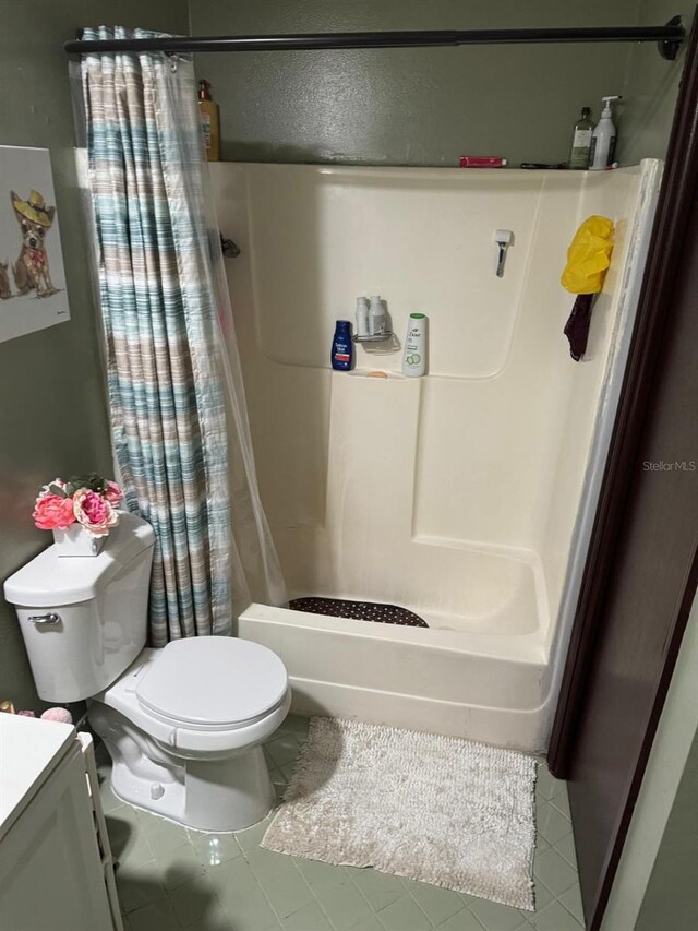 111 Carillo St NE, Palm Bay, FL 32907 - bathroom featuring toilet, tile patterned flooring, vanity, and shower / bathtub combination with curtain
