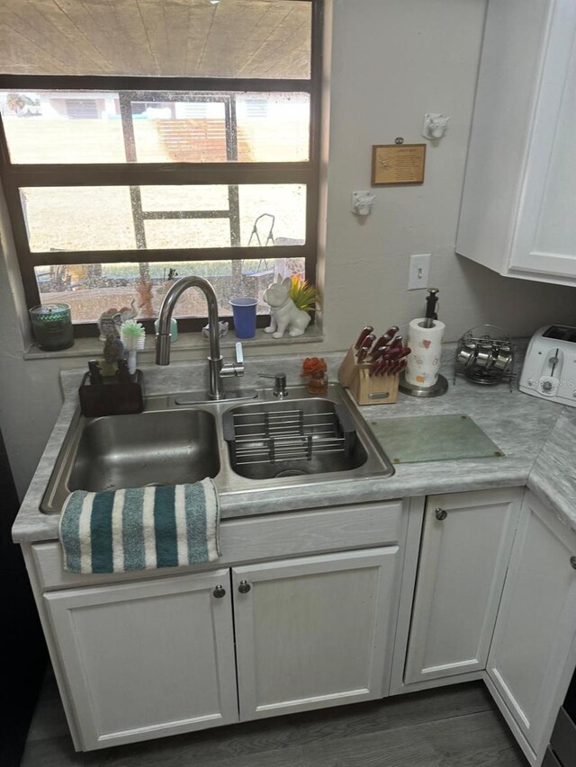 111 Carillo St NE, Palm Bay, FL 32907 - kitchen with a sink, light countertops, white cabinets, and dark wood-style floors