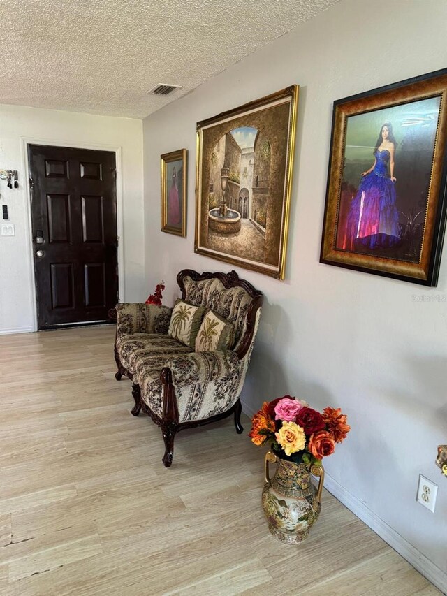 111 Carillo St NE, Palm Bay, FL 32907 - sitting room with light wood-style flooring, a textured ceiling, and baseboards