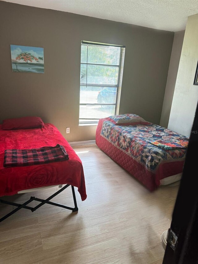 111 Carillo St NE, Palm Bay, FL 32907 - bedroom with baseboards, wood finished floors, and a textured ceiling