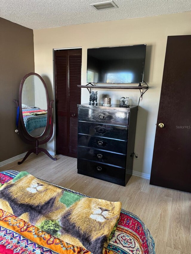 111 Carillo St NE, Palm Bay, FL 32907 - bedroom with light wood-style floors, a textured ceiling, a closet, and baseboards
