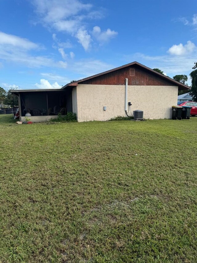 111 Carillo St NE, Palm Bay, FL 32907 - view of home's exterior featuring a yard, central air condition unit, a sunroom, and stucco siding