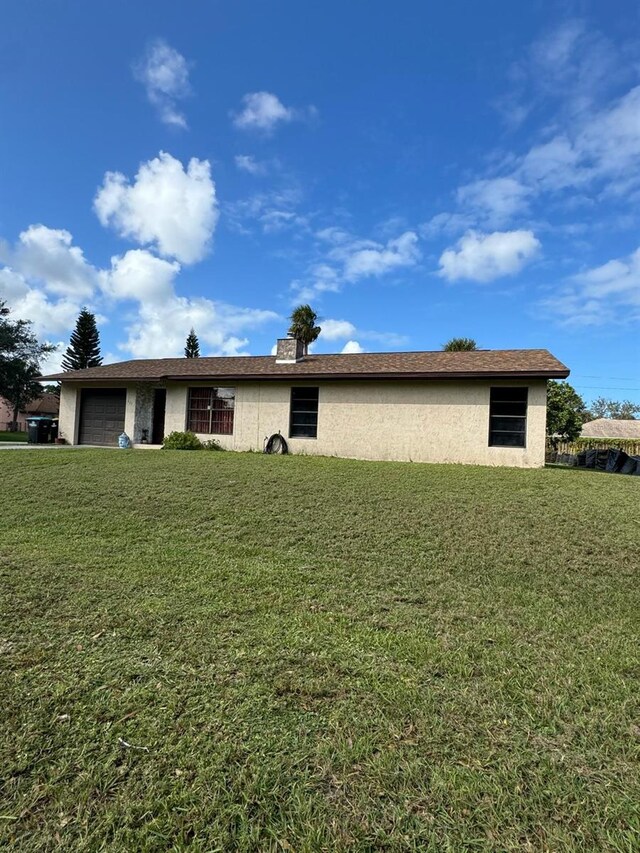 111 Carillo St NE, Palm Bay, FL 32907 - view of front of home featuring a garage, a front lawn, and stucco siding