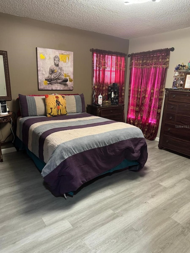 bedroom featuring light hardwood / wood-style flooring and a textured ceiling